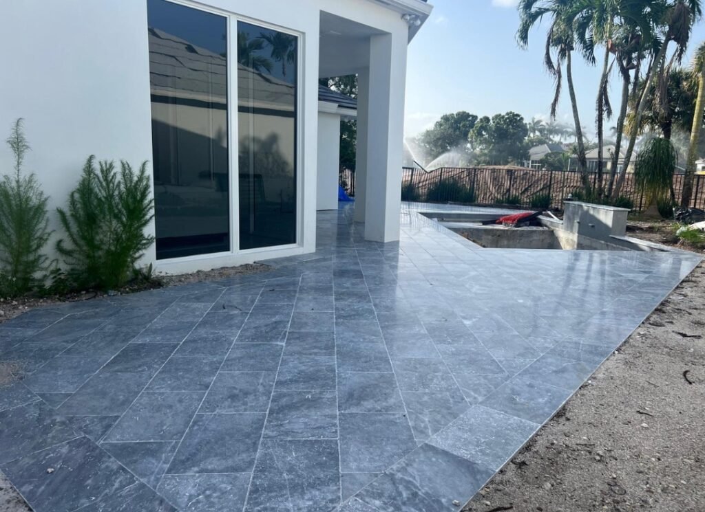 Gray marble patio laid on a diagonal beside sliding glass doors