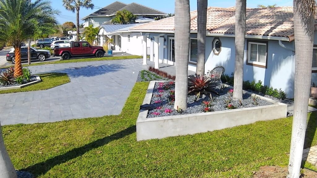Gray paver driveway around a raised planter from the same job