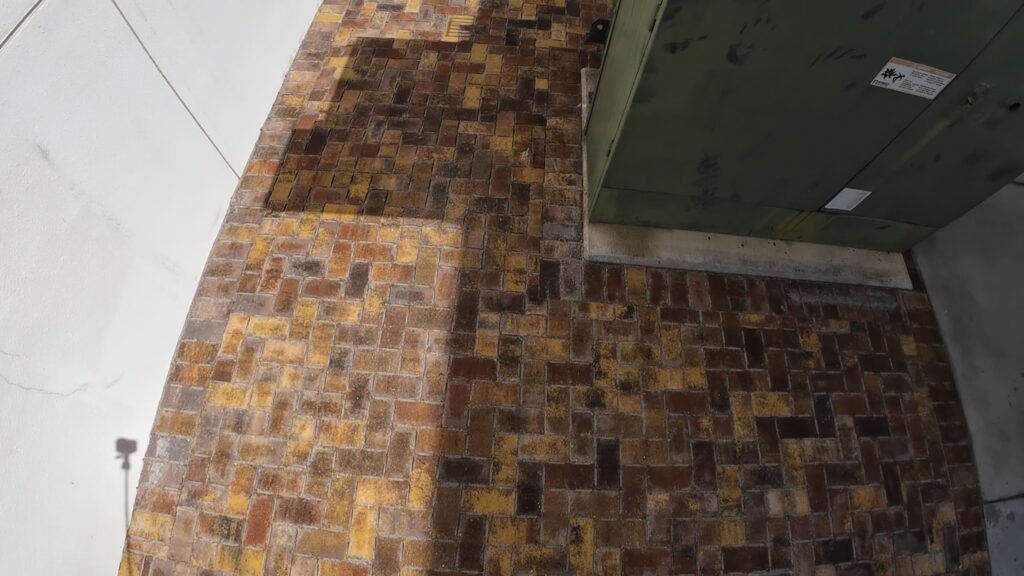 Finished brick paver repair next to green utility boxes in Boca Raton